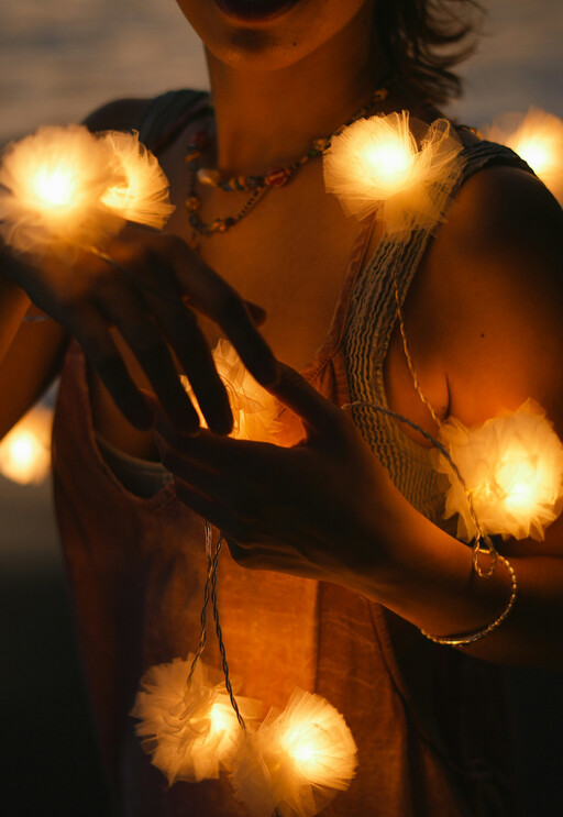 Junge Frau bestückt mit leuchtenden Blumen
